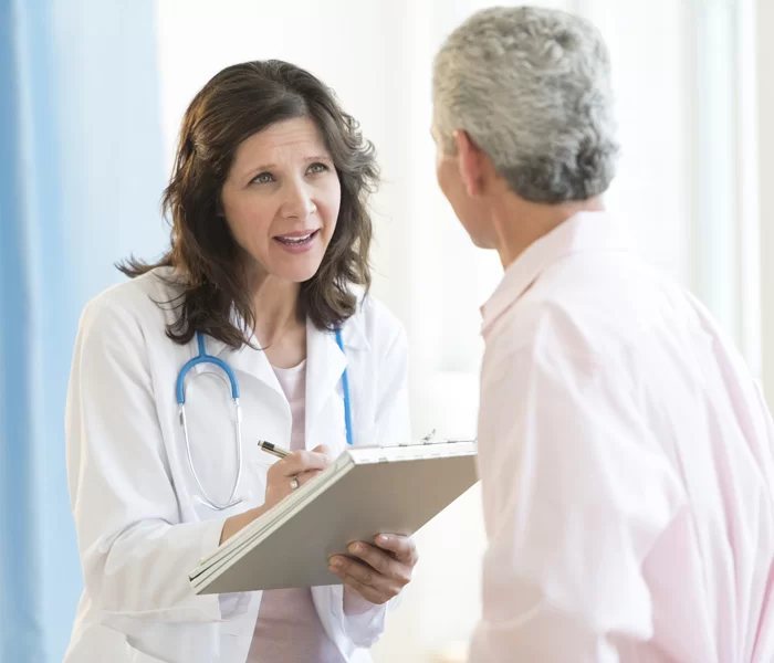 Mature female doctor discussing with patient in hospital shutterstock 147933542 700215600 1